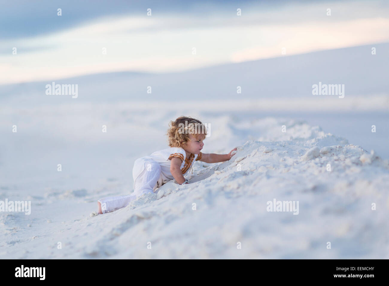 Ragazzo caucasico climbing duna di sabbia Foto Stock