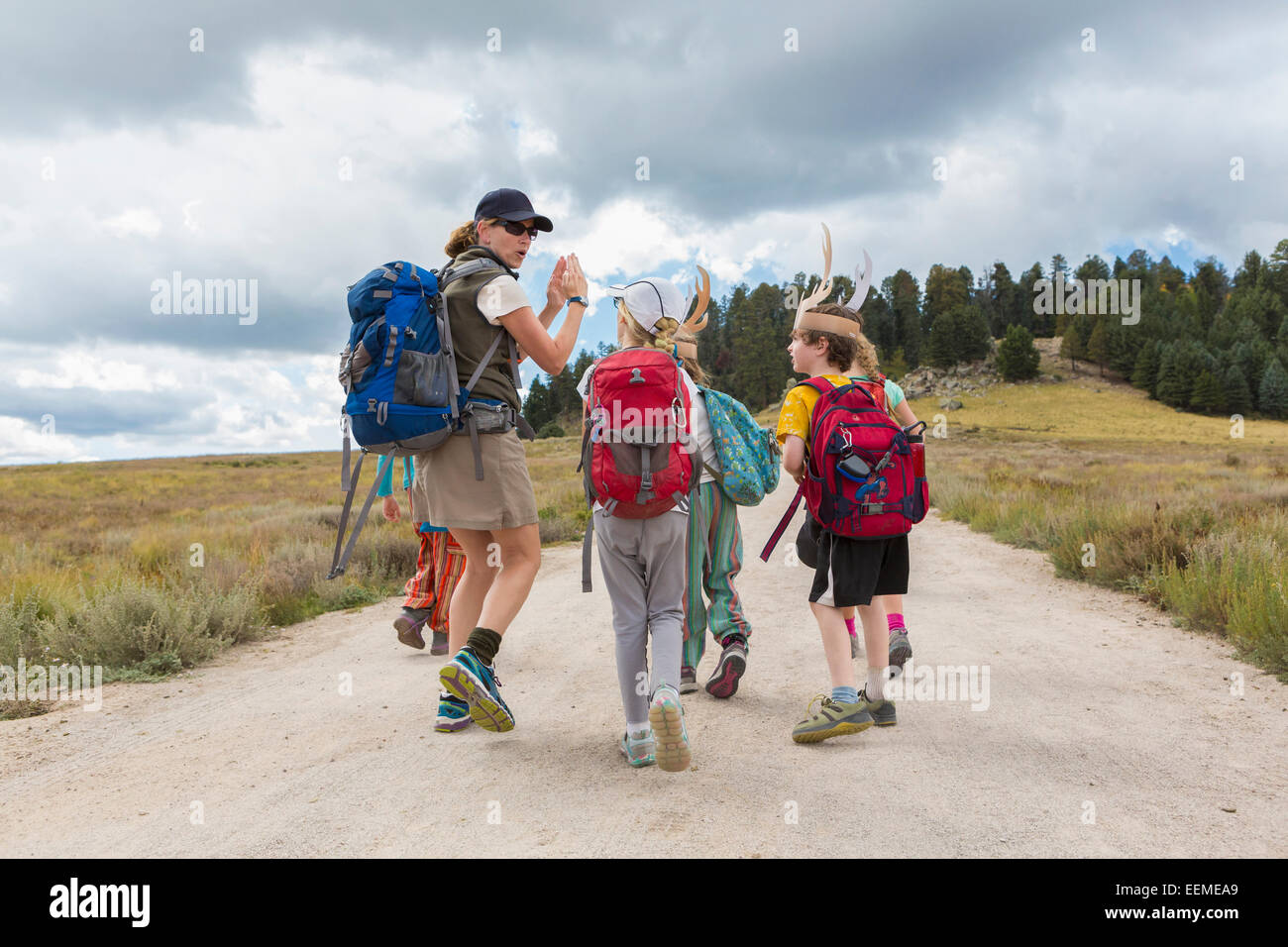 Escursionista caucasici che portano i bambini sul percorso nel paesaggio remoto Foto Stock