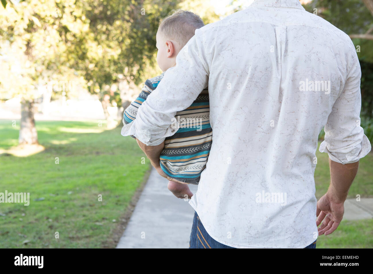 Padre caucasici che porta il figlio sul marciapiede Foto Stock