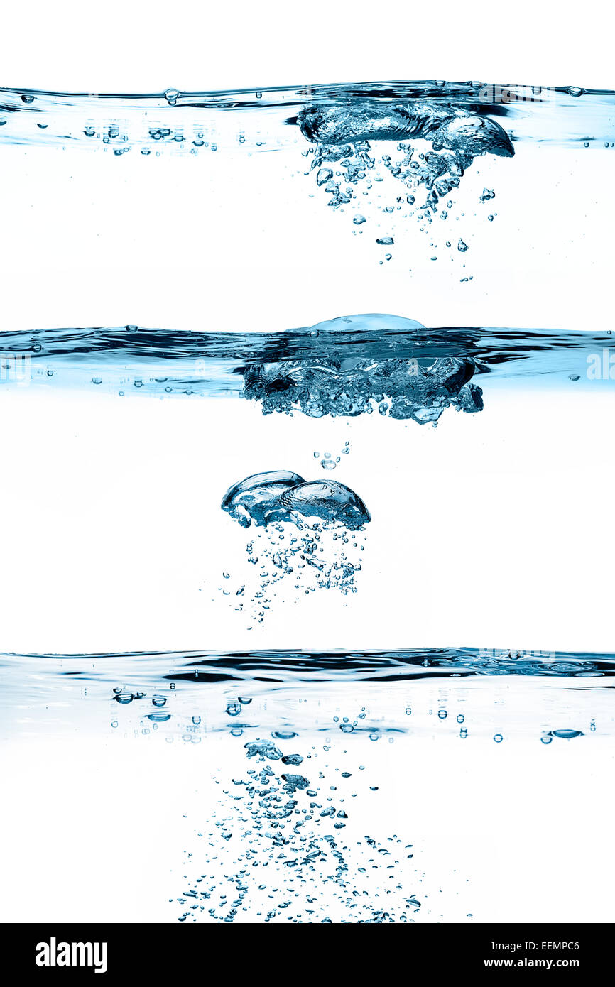 Primo piano di tre linee di galleggiamento con bolle di ossigeno in acqua blu Foto Stock