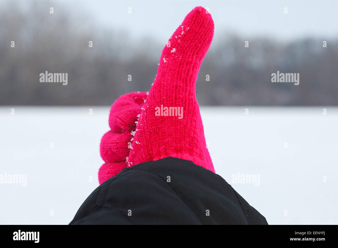 Foto di mano in rosso guanto con il pollice fino a sfondo Inverno in natura, il concetto di gioia nel periodo invernale Foto Stock