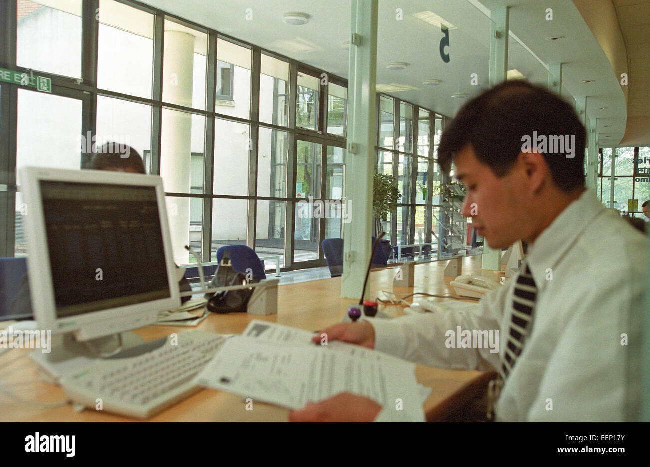 Autorità locale dipendente dietro un contatore interviste un richiedente nel consiglio di consulenza vantaggi di Office, Regno Unito Foto Stock