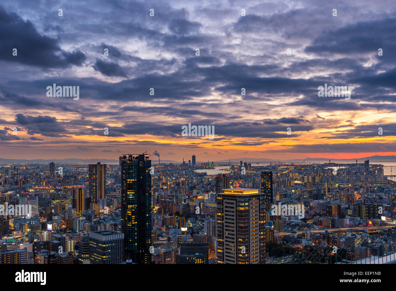 Il sole tramonta oltre il vasto paesaggio di Osaka, in Giappone. Foto Stock