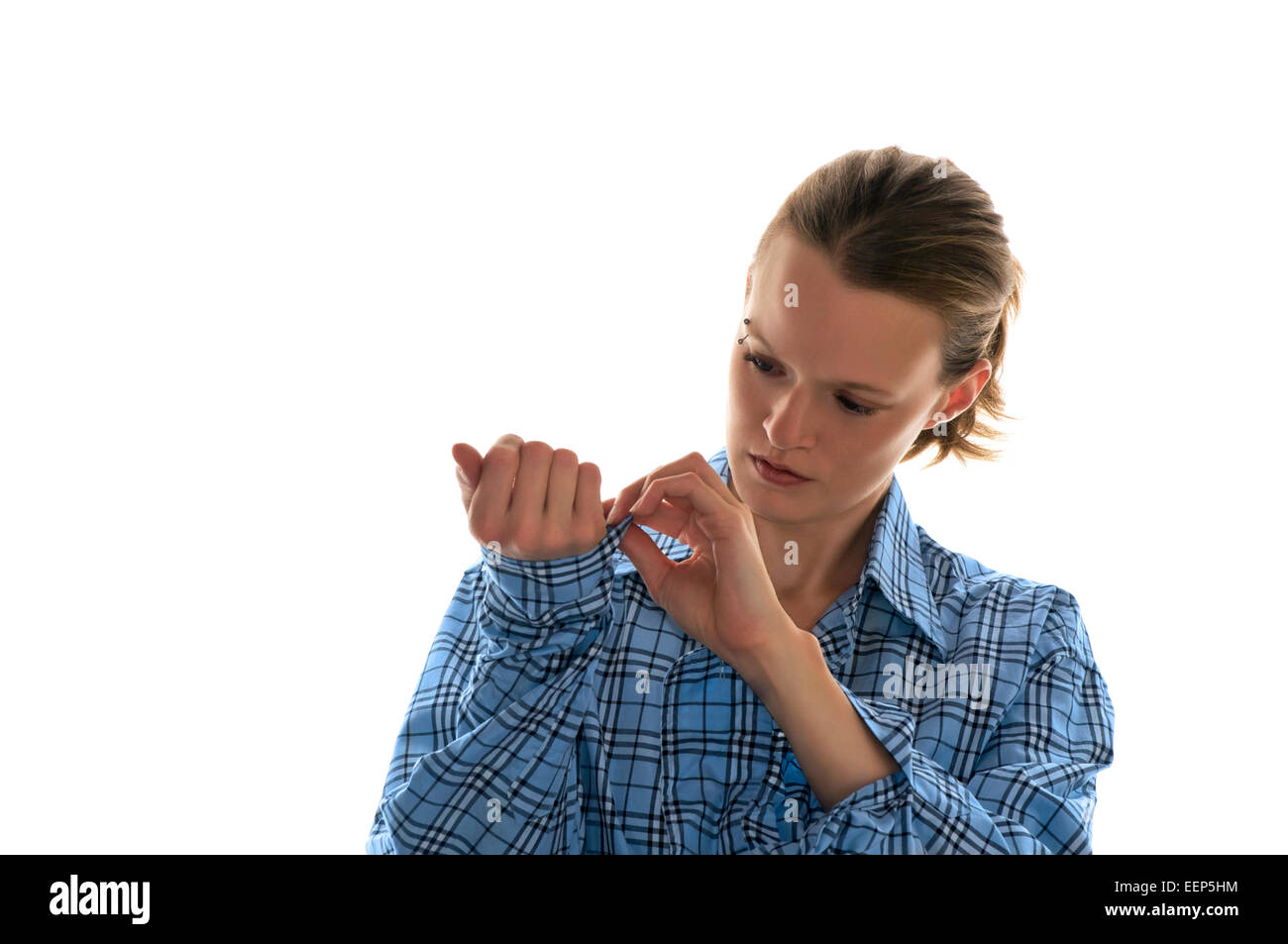 Belli i pulsanti femmina fino al bracciale del suo plaid vestito blu camicia. Foto Stock