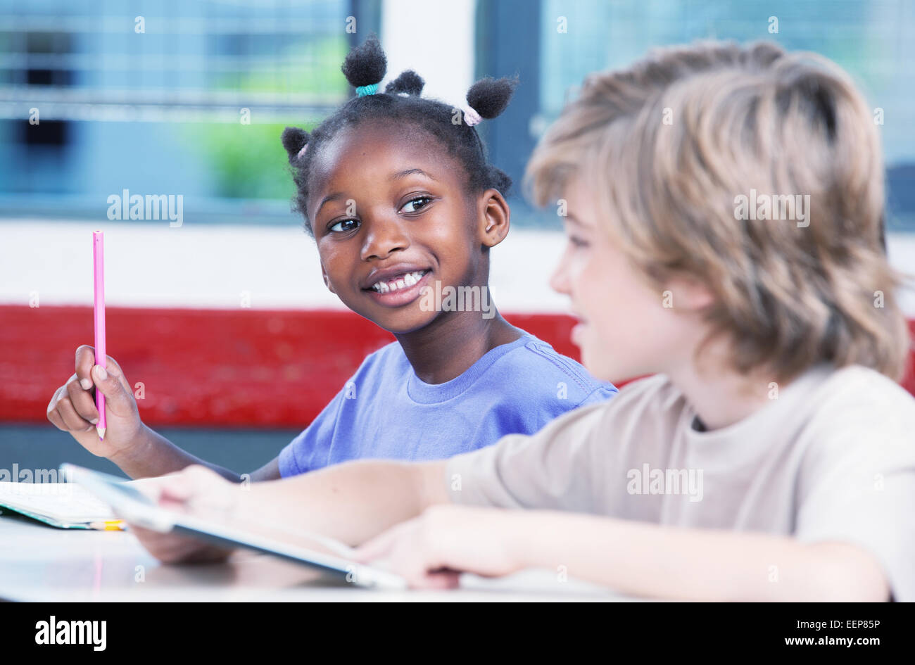 Multi-etnico in aula. Studente Afroamerican parlando di classmate caucasica. Foto Stock