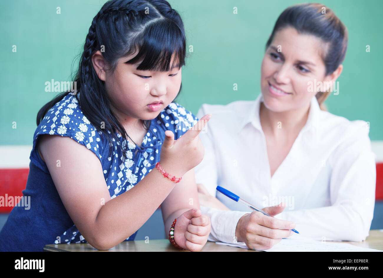 Femmina asiatica di apprendimento dello studente per il conteggio con il suo insegnante. Foto Stock