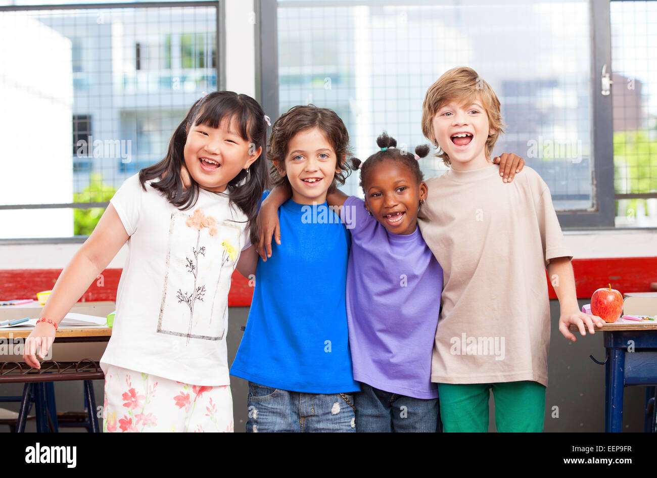 Multi etnico in aula. Afro-americani, asiatici e caucasici scuola primaria bambini sorridenti. Foto Stock