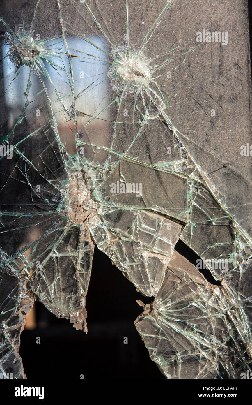 Finestra in vetro di sicurezza, vetro retinato, fracassato, frammentato, con fori. In corrispondenza di una rovina industriale Foto Stock