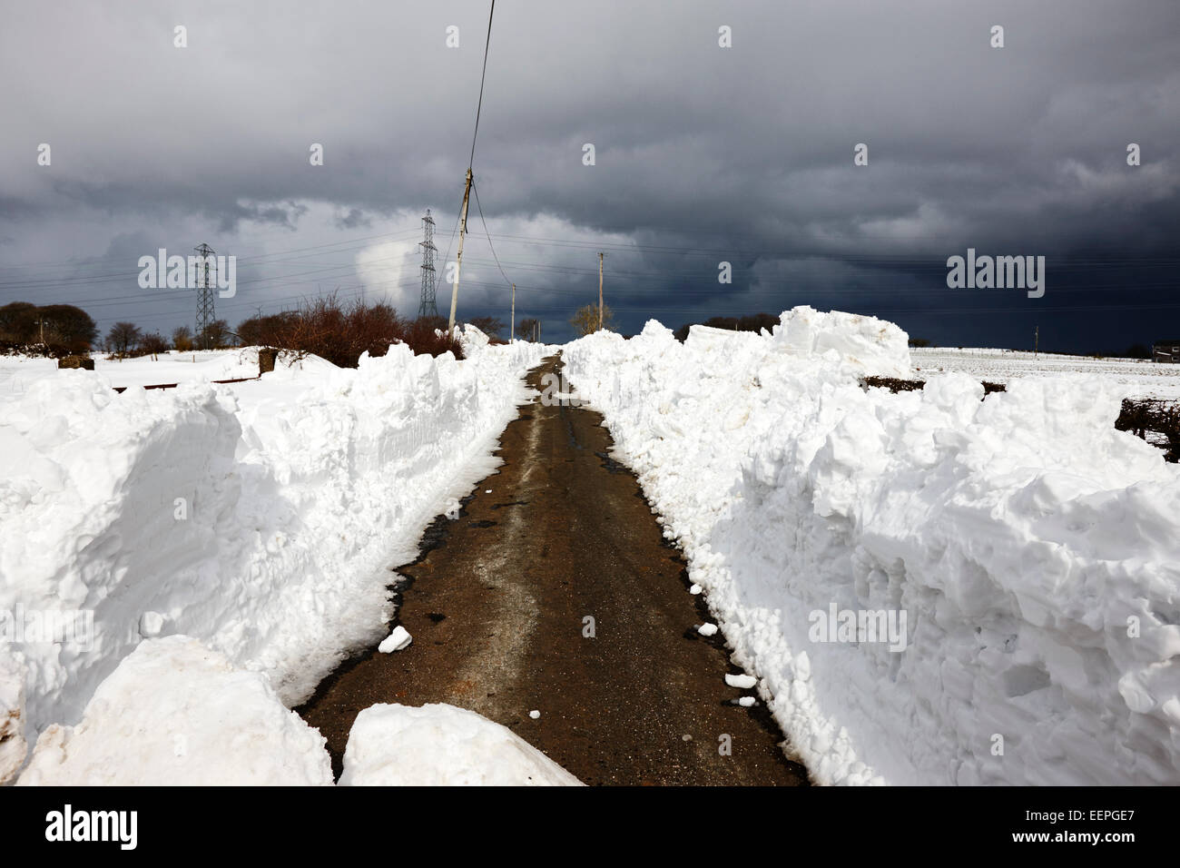 Taglio di percorso attraverso cumuli di neve durante l'inverno Irlanda del Nord Foto Stock