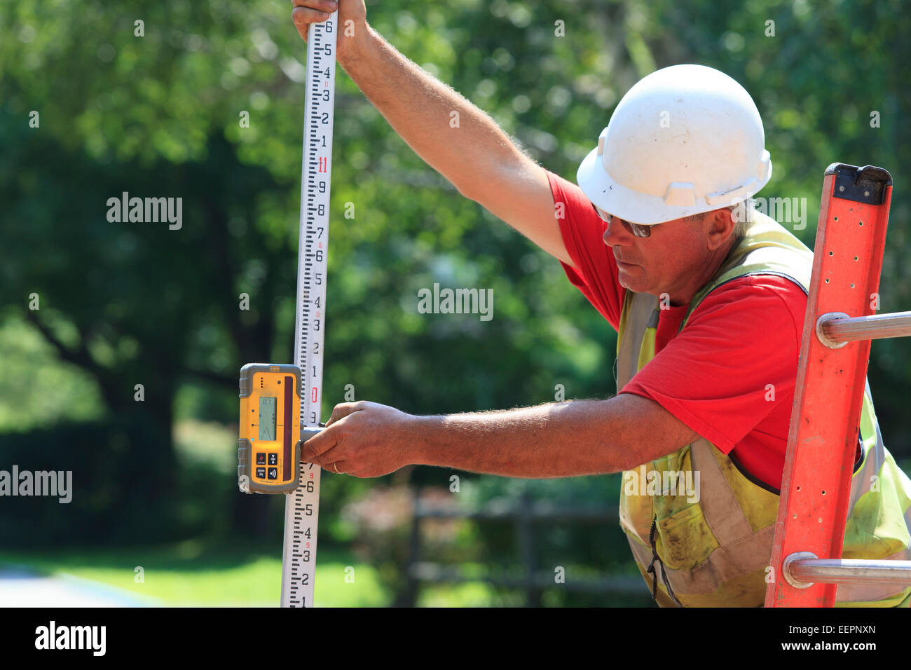 Supervisore di costruzione utilizzando electronic Barra per rilievi topografici Foto Stock