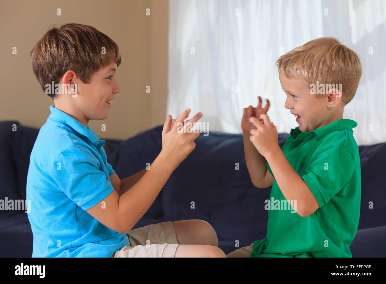 Ragazzi con problemi di udito firma 'basketball' in American Sign Language sul loro lettino Foto Stock