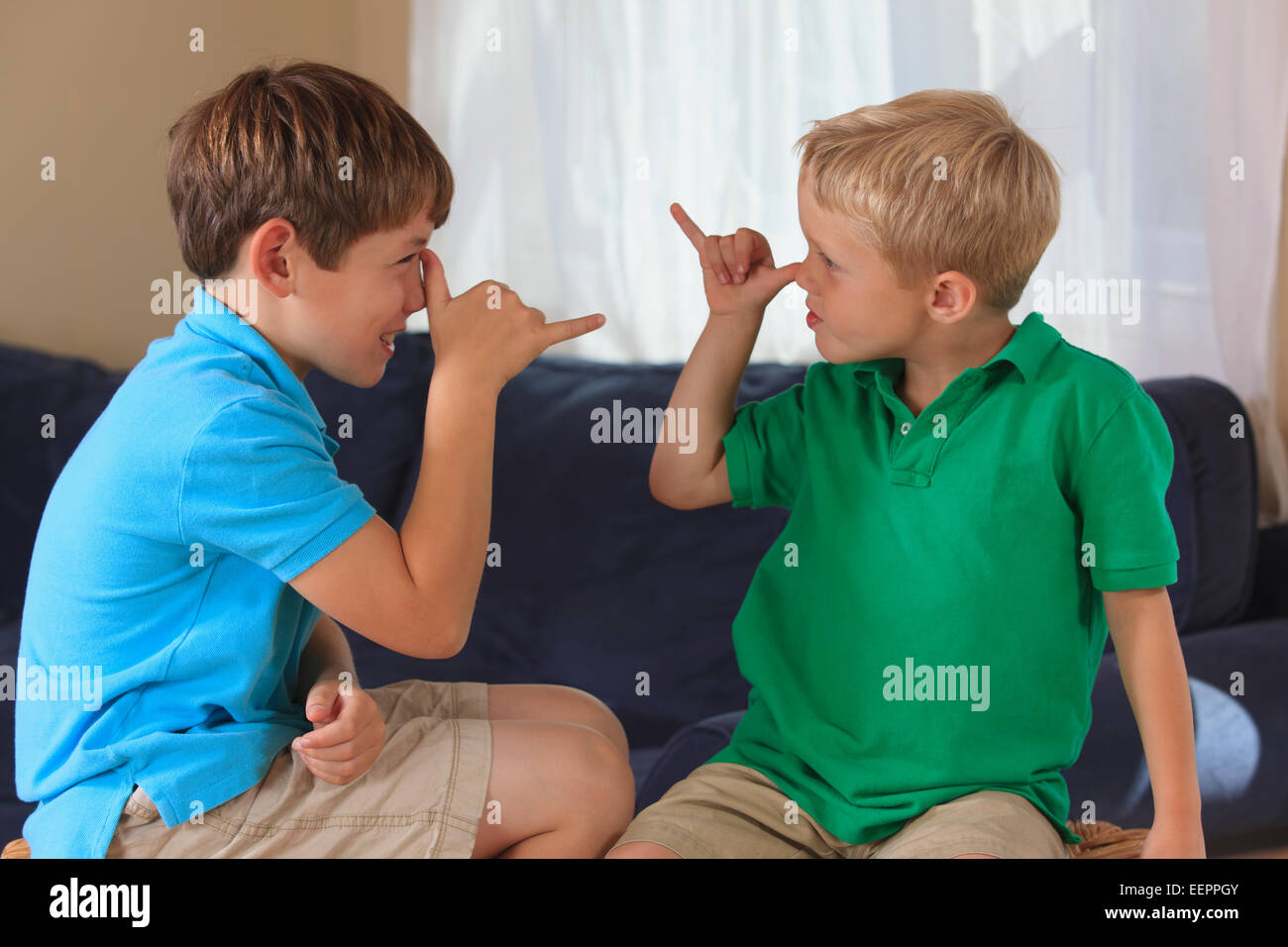 Ragazzi con problemi di udito firma 'silly' in American Sign Language sul loro lettino Foto Stock