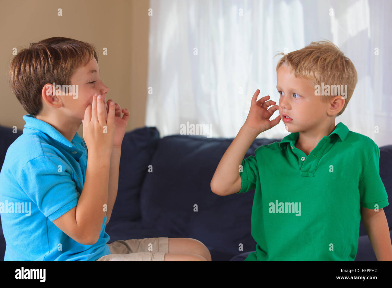 Ragazzi con problemi di udito firma 'cat' in American Sign Language sul loro lettino Foto Stock