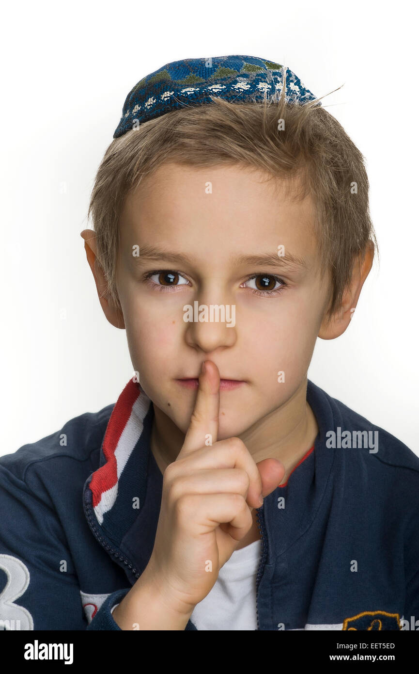 Ritratto in studio di ragazzo bianco con gli Ebrei kipa o yarmulke rendendo gesto essere silenzioso Foto Stock