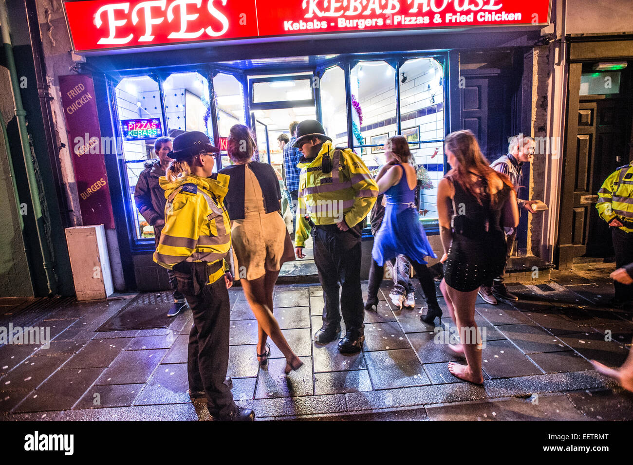 Gli ufficiali di polizia poliziotti a parlare con le giovani donne in Aberystwyth al di fuori di una casa di kebab shop negozio di alimentari a tarda notte dopo aver festeggiato il 2015 anno nuovo. Regno Unito Foto Stock