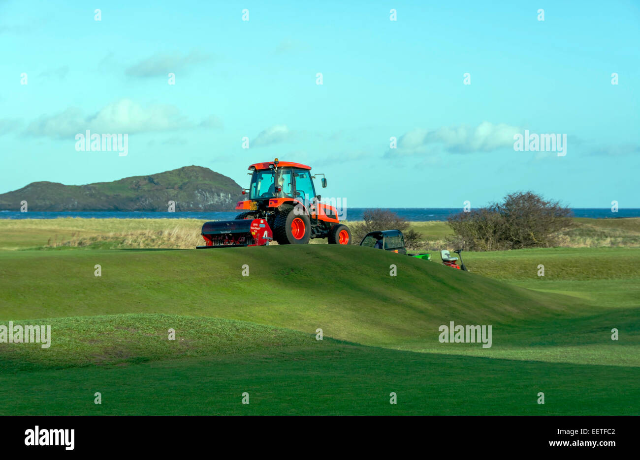 I lavori di manutenzione effettuati su un campo da golf. Il trattore è la scarificatrice il fairway. Foto Stock