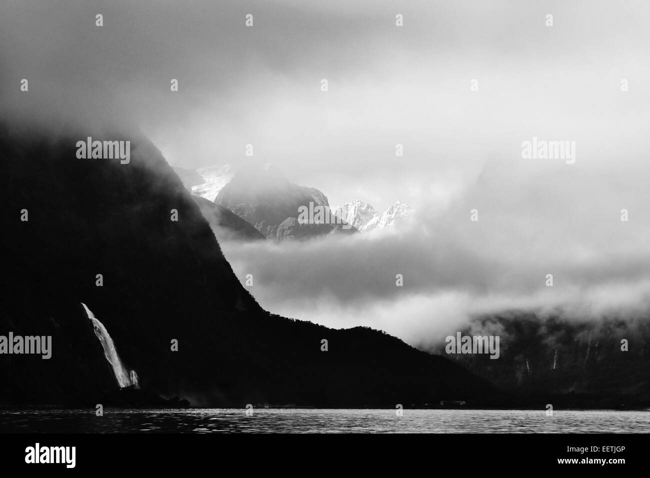 Bowen falls, Milford Sound, come le Alpi Meridionali peer attraverso le nuvole ad est. Foto Stock