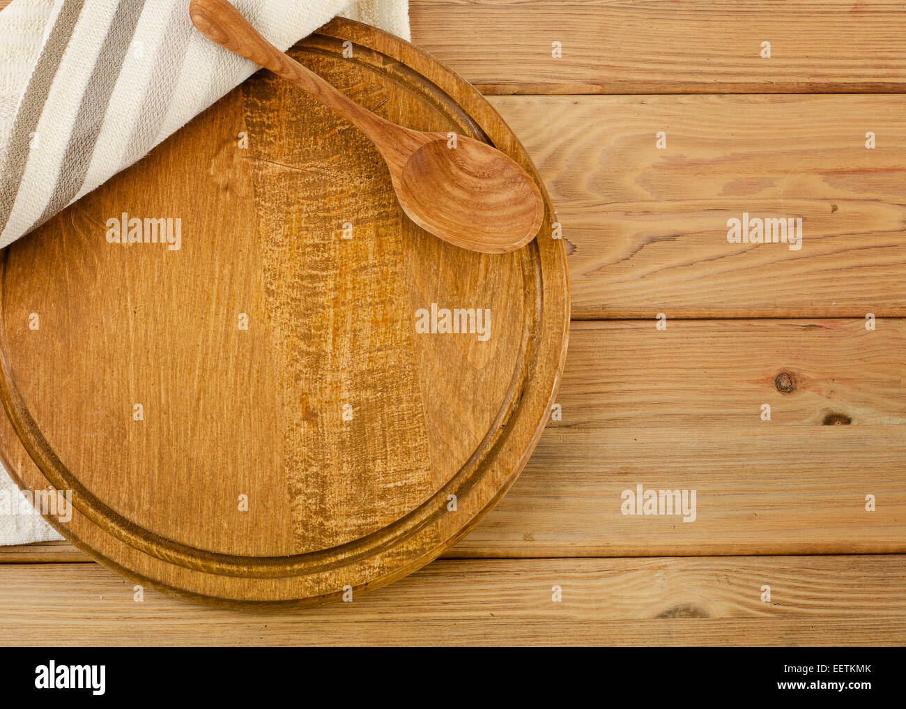 Tovagliolo con il cucchiaio di legno su una tavola di legno Foto Stock