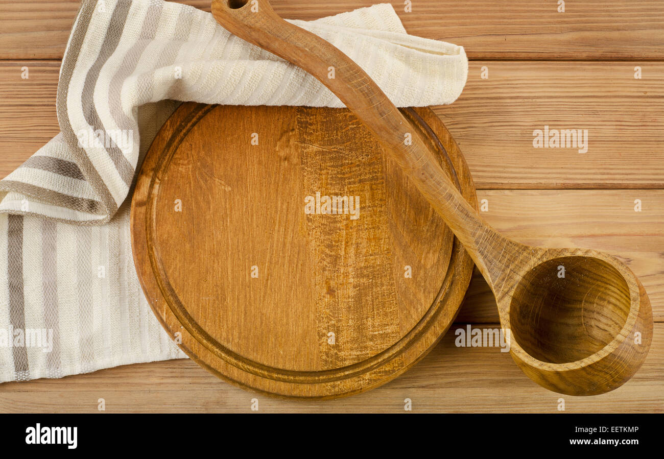 Tovagliolo con il cucchiaio di legno su una tavola di legno Foto Stock