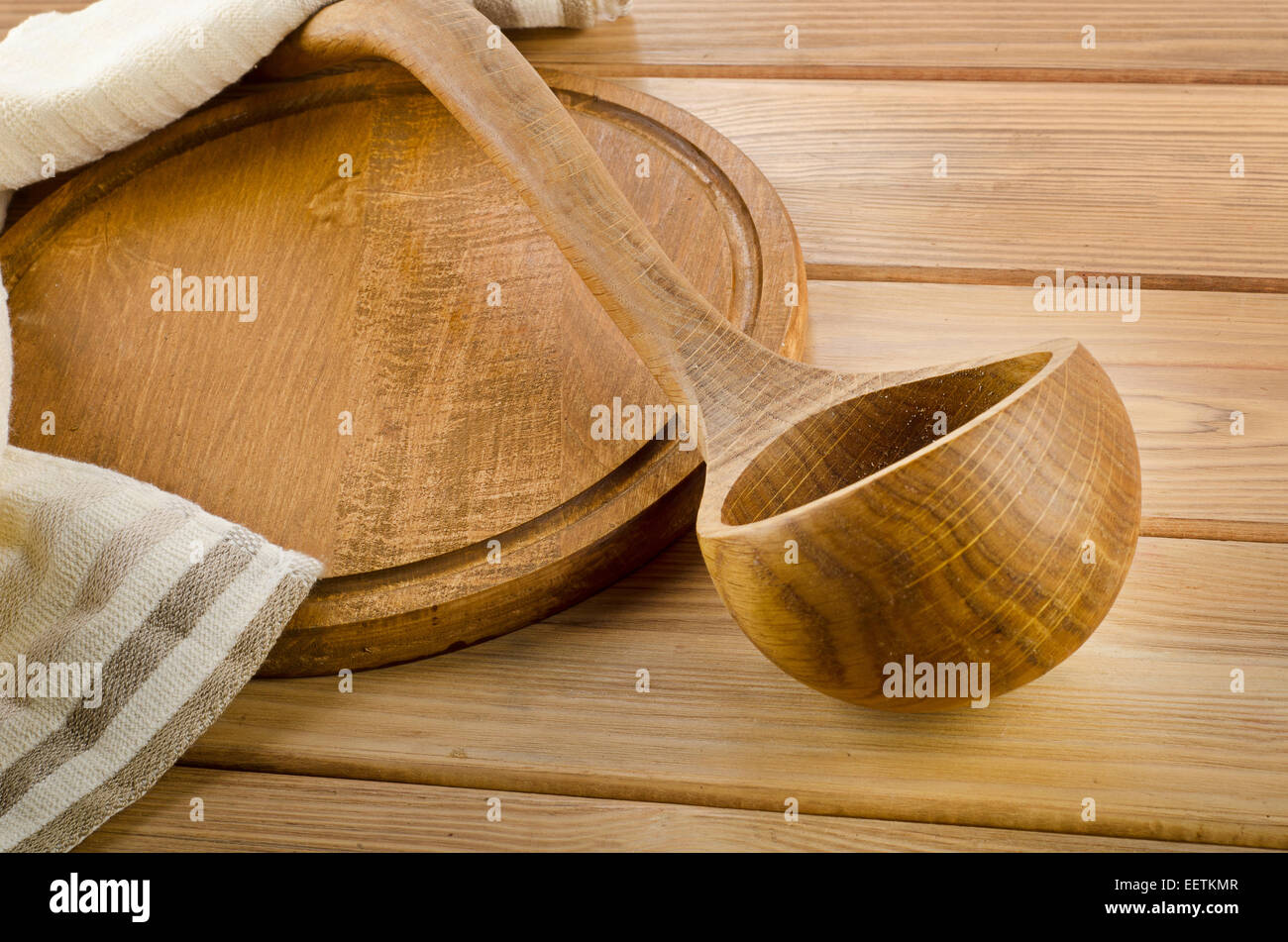 Tovagliolo con il cucchiaio di legno su una tavola di legno Foto Stock
