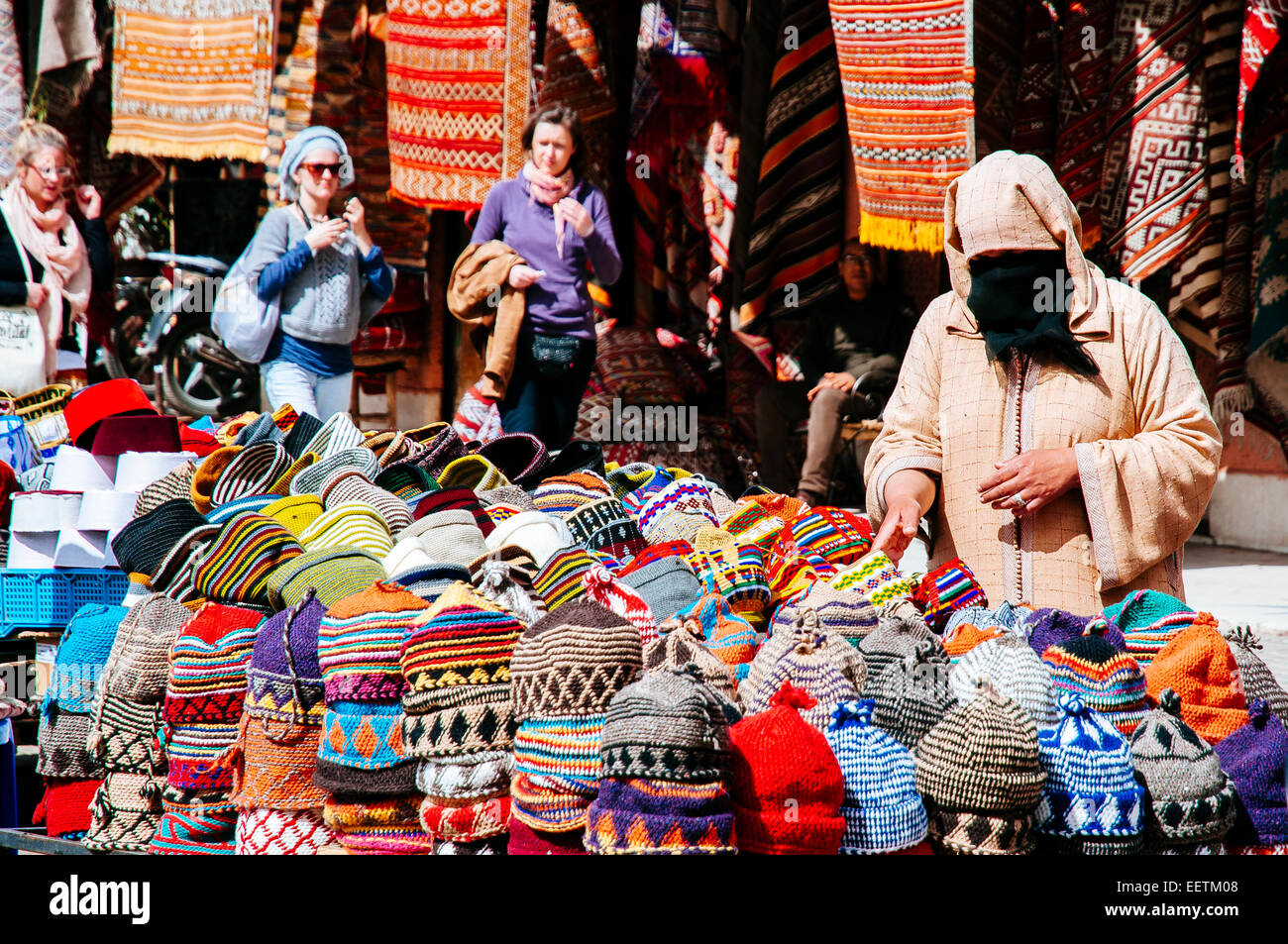 Donna in djellaba presso un cappello street in stallo Rahma Qedima square. Marrakech, Marocco Foto Stock