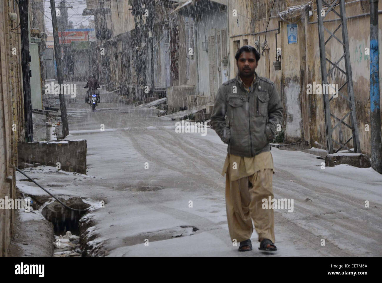 L'uomo passando attraverso la strada durante la nevicata come capitale provinciale di Balochistan accoglie favorevolmente prima nevicata caduta della stagione invernale su Mercoledì, 21 gennaio 2015. Servizio meteorologico ha previsto più nevicata di Quetta e le sue aree adiacenti alla prossima 24 Ore e il meteo a Karachi potrebbe anche restare freddo nido per uno o due giorni. Foto Stock