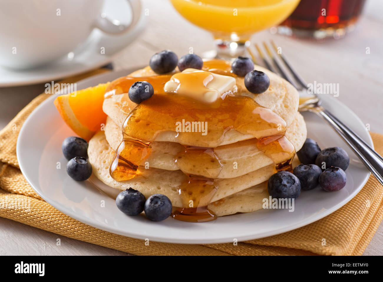 Una piastra di deliziosi pancake con mirtilli freschi e sciroppo d'acero. Foto Stock