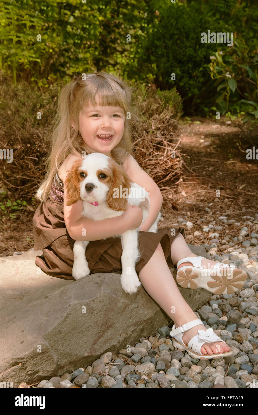Bimba di tre anni tenendo una femmina Cavalier King Charles Spaniel, Mandy,  15 settimane vecchio cucciolo, nella parte occidentale di Washington, Stati  Uniti d'America Foto stock - Alamy