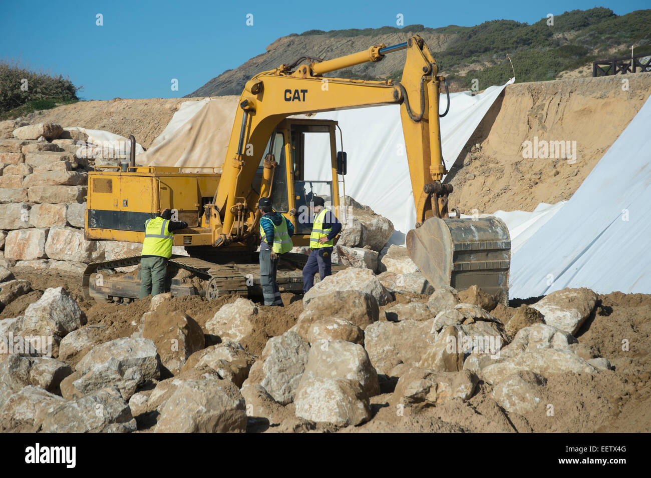 Operai che lavorano sulla difesa del mare in Portogallo Foto Stock