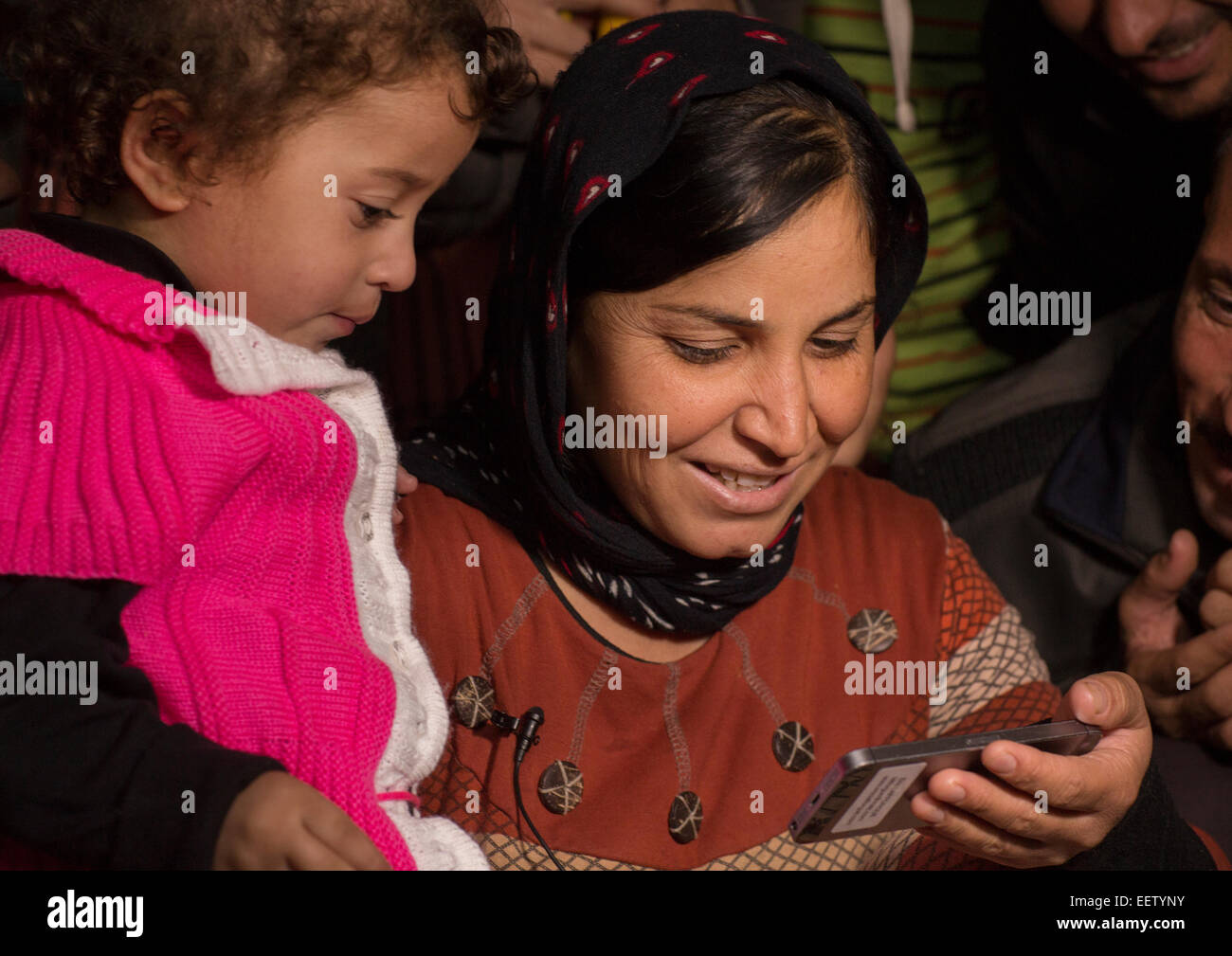 Yezedi rifugiati da Sinjar facendo una conferenza su un telefono mobile con i parenti, Zocar, Kurdistan, Iraq Foto Stock