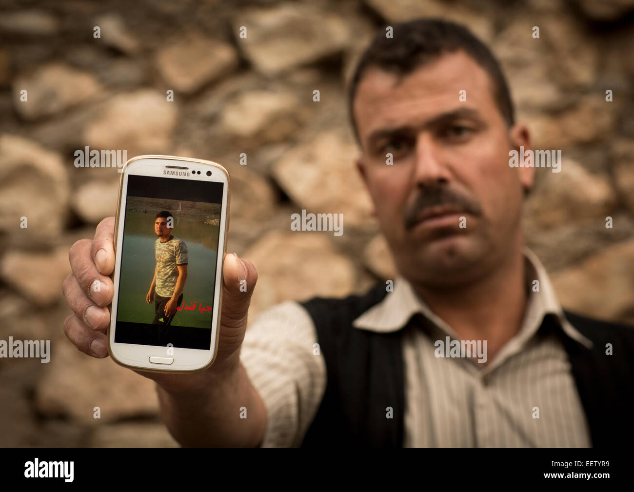 Yezedi profughi dal Sinjar che mostra la foto del suo parente morto ucciso da Daesh sul suo telefono cellulare, Lalesh tempio, Kurdista Foto Stock