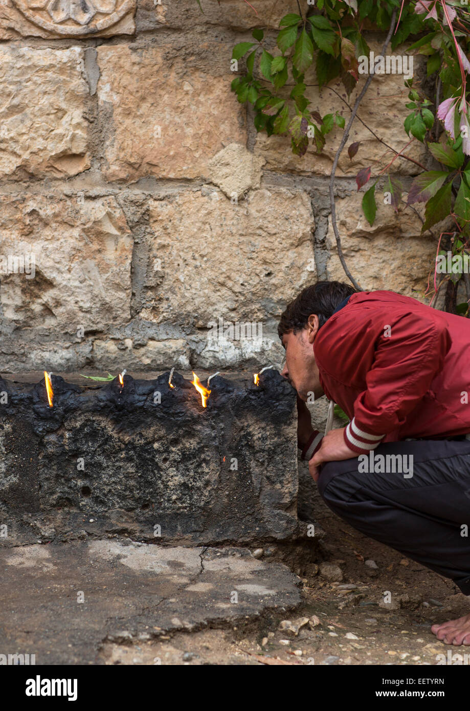 Uomo Yezedi baciare il sacro fuoco, Lalesh tempio, Kurdistan, Iraq Foto Stock