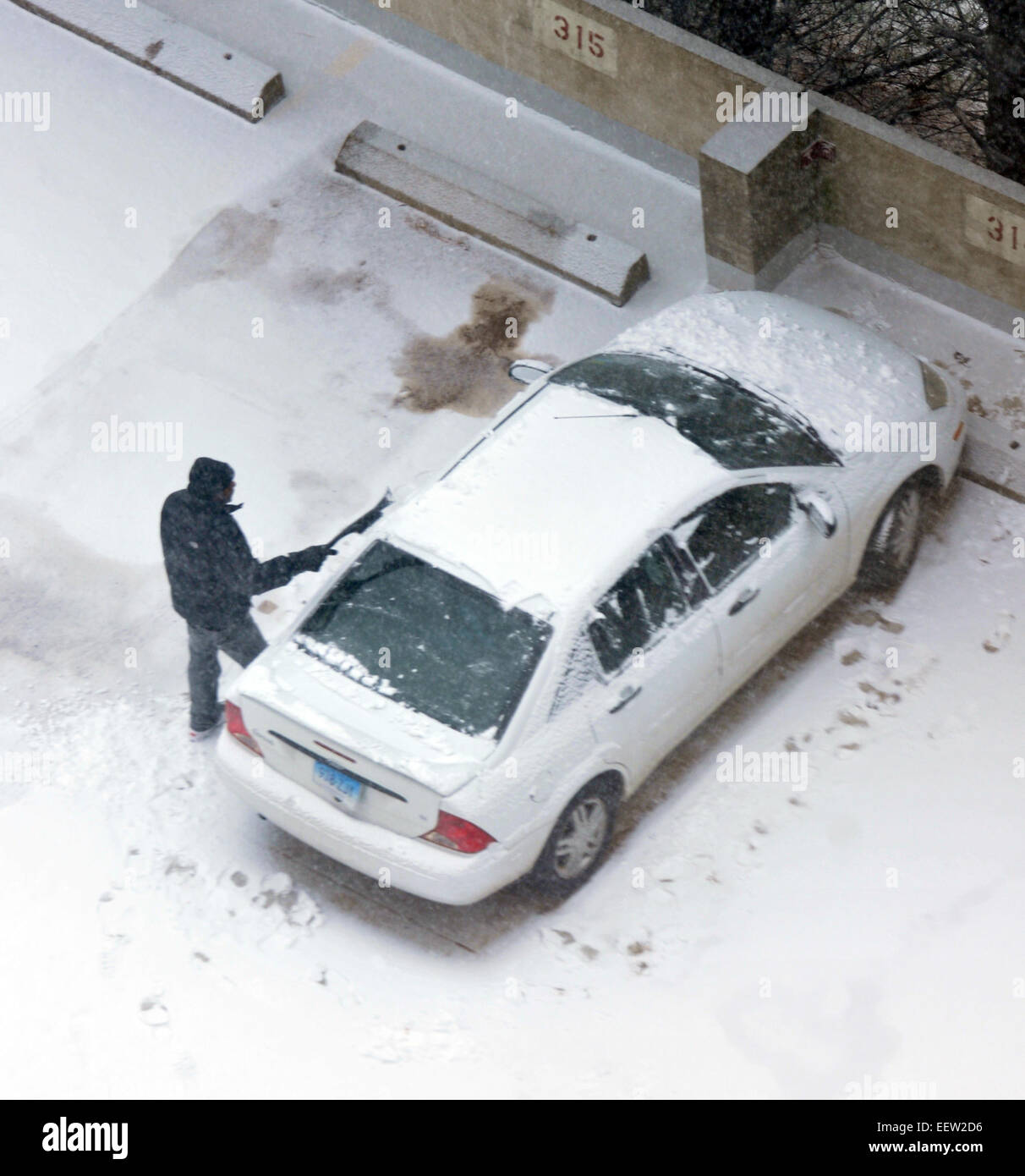 New Haven-- Un uomo libera dalla sua vettura al Bella Vista alloggiamento senior complesso come la neve inizia a cadere. Foto Stock