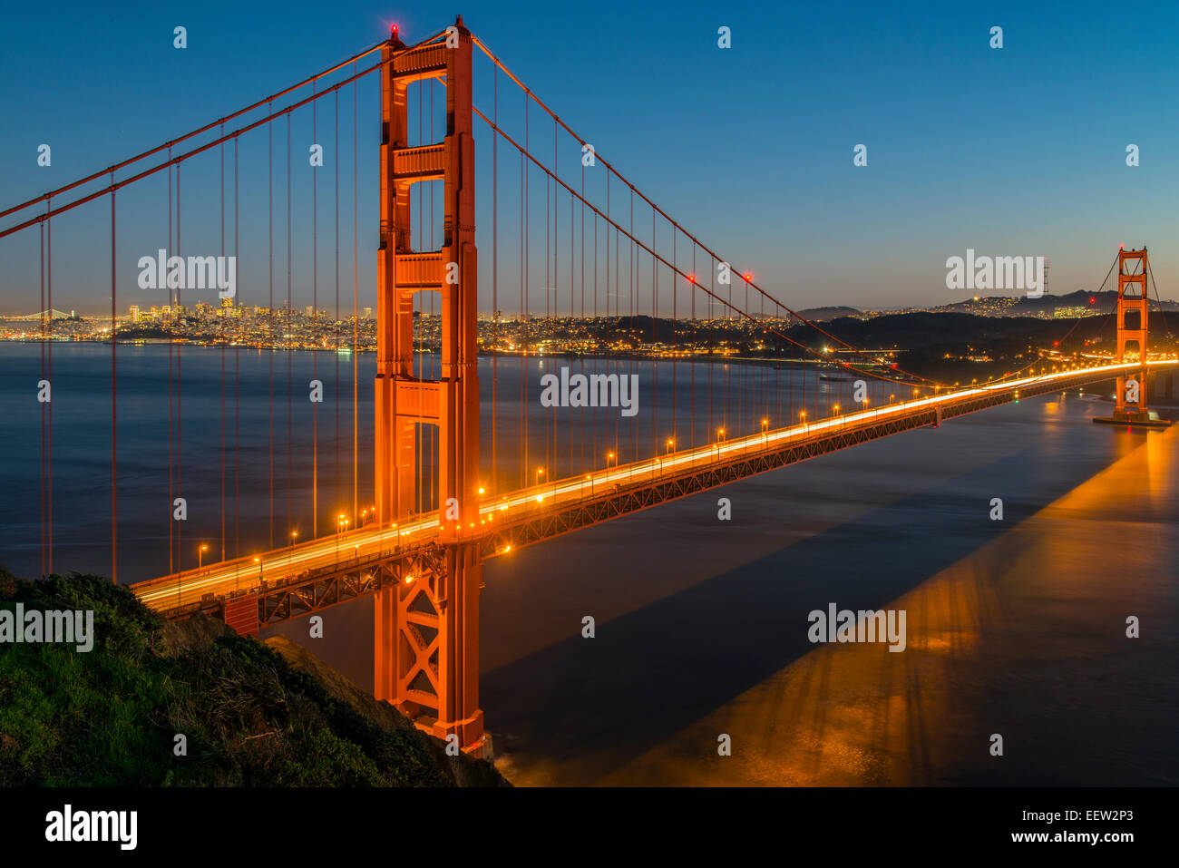 Vista notturna del Golden Gate bridge di sospensione con lo skyline della città in background, San Francisco, California, Stati Uniti d'America Foto Stock