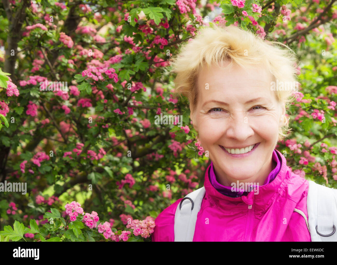 Ritratto di donna sportiva della media degli anni a una fioritura biancospino Foto Stock