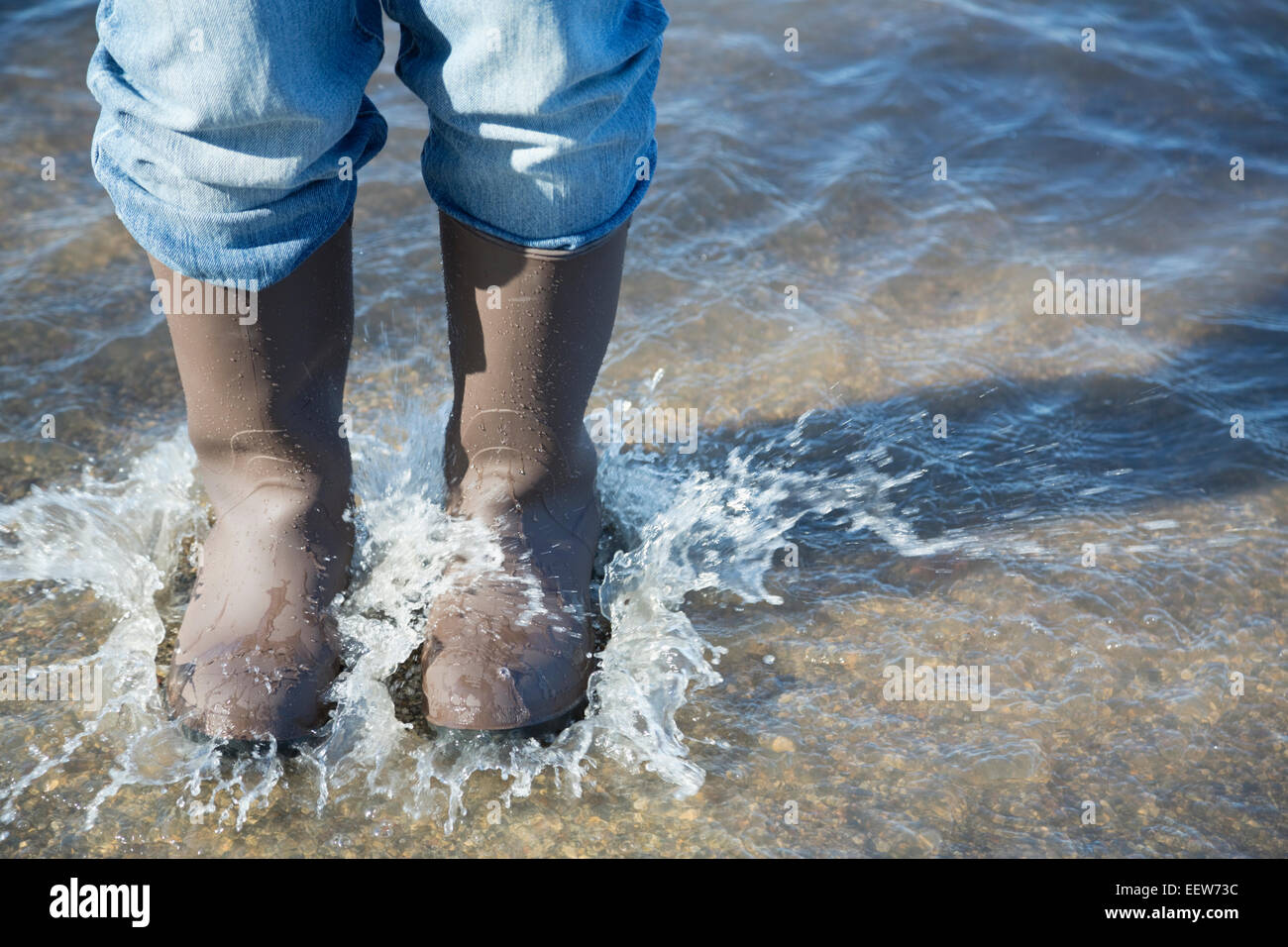 Uomo in piedi in strada allagata Foto Stock