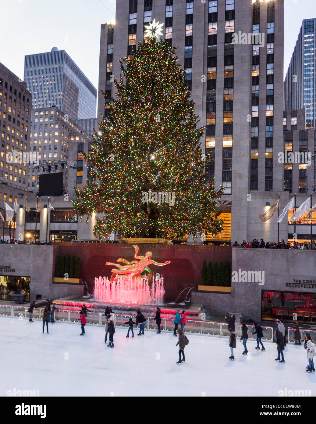 Pattinaggio al di sotto del nuovo albero di Natale illuminato. I pattinatori godendo il pattinaggio sul ghiaccio al Rockefeller Center con le luci delle vacanze Foto Stock