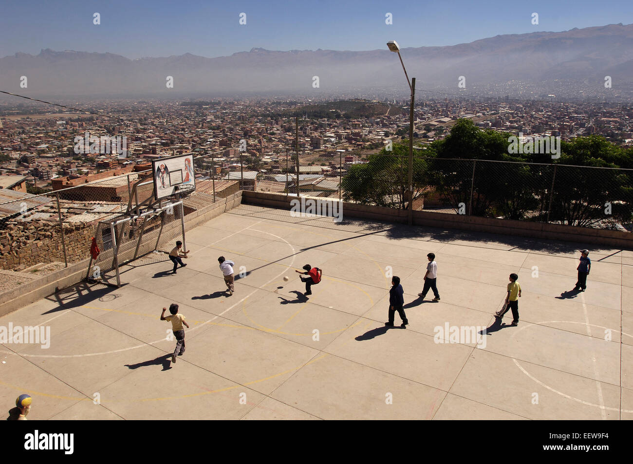 Ragazzi che giocano a calcio contro lo sfondo delle Montagne Andine nella città di Cochabamba, in Bolivia. Foto Stock