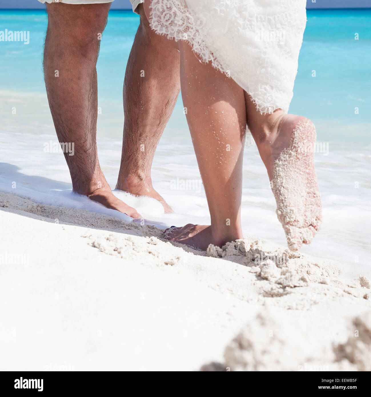 Chiudere fino a maschio e femmina i piedi sulla sabbia bianca, kissing Foto Stock