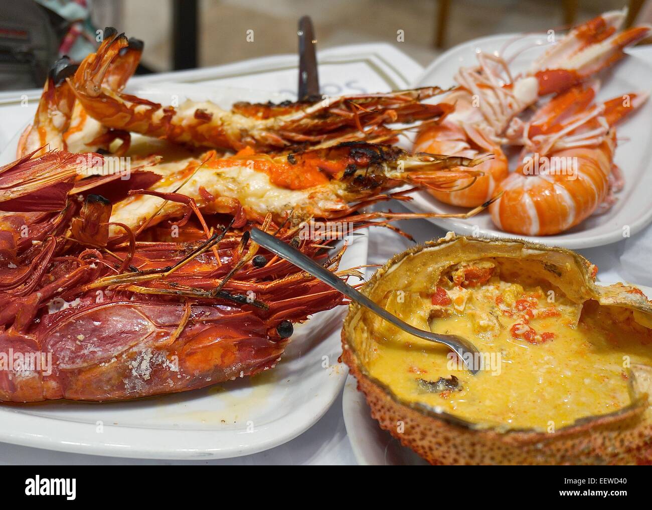 Piastre di piatti a base di frutti di mare (in senso orario dal basso a destra): granseola shell, scarlatto, gamberi tigre gigantesca gamberetti, aragosta norvegese Foto Stock