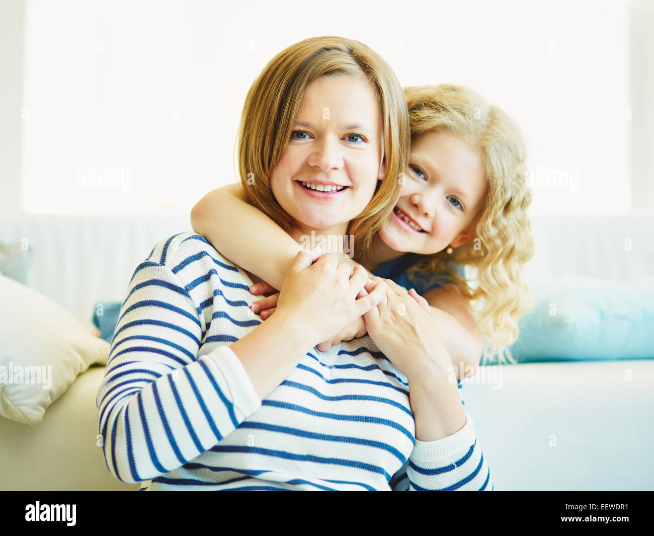 Affettuosa giovane ragazza abbracciando la madre Foto Stock