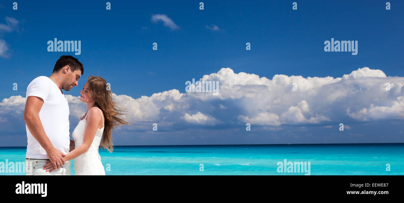 Sposa e lo sposo cercando di ogni altro e tenendo le mani, romantica vacanza in spiaggia Caraibica Foto Stock