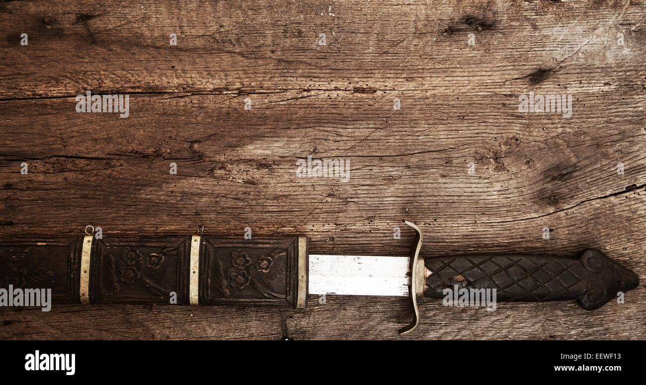 Ampia la spada su sfondo di legno Foto Stock