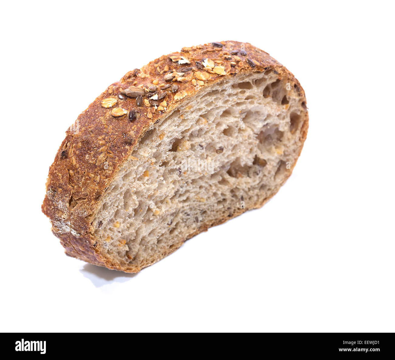 Grano intero fetta di pane su sfondo bianco, vista diagonale con messa a fuoco poco profonda Foto Stock