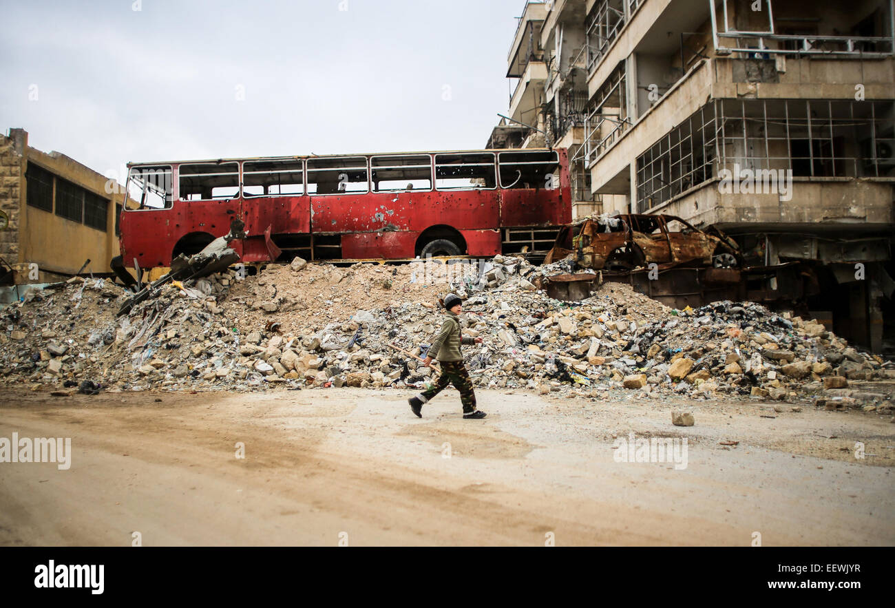 Bambino spotted walking in macerie di Aleppo. I membri di al-Qaeda di diversa nazionalità, essi si trovano in una zona denominata Air Force Intelligence di Aleppo combattimenti con al-Assad di elementi dell'esercito in prima linea. © Ibrahim Khader/Pacific Press/Alamy Live News Foto Stock