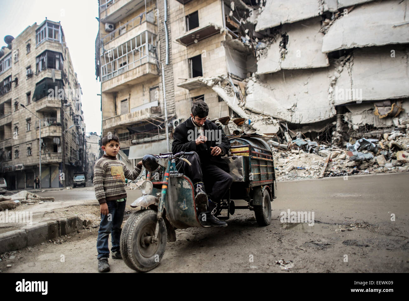 Padre e figlio raccoglie le cose in edifici abbandonati. I membri di al-Qaeda da diverse nazionalità (non visibile), nascondere in una zona chiamata Bustan al-qasr di Aleppo combattimenti con al-Assad di elementi dell'esercito in prima linea. © Ibrahim Khader/Pacific Press/Alamy Live News Foto Stock