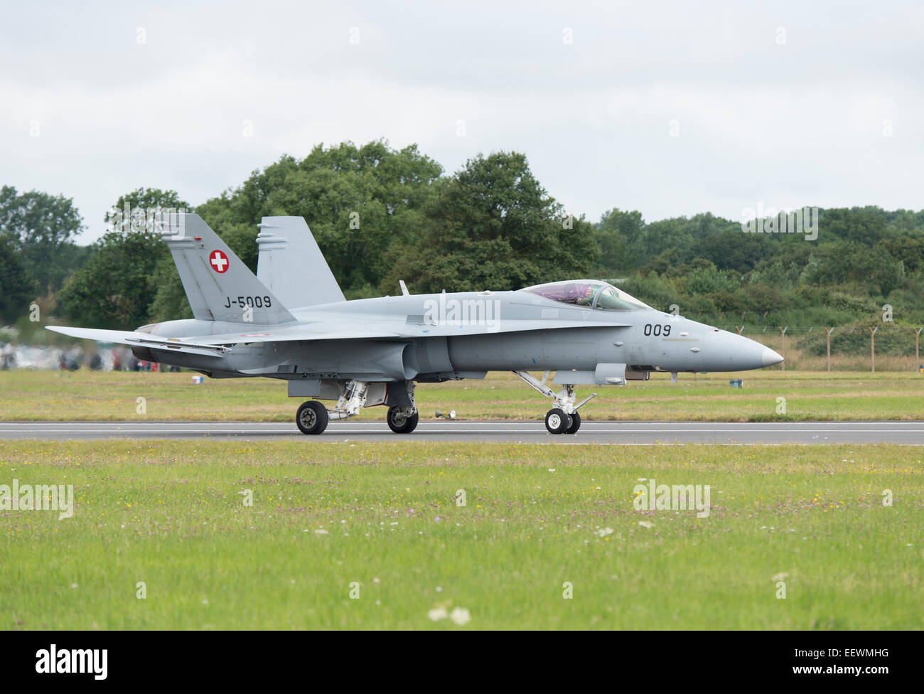 Il pilota della Swiss Air Force F/A-18C Hornet Jet militare Fighter onde per la folla dopo aver completato il suo display a RIAT Foto Stock