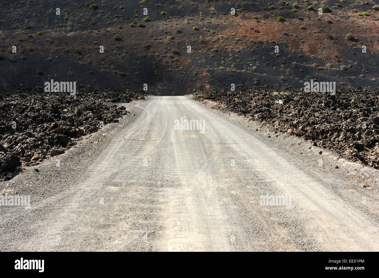Una strada sul selvaggio paesaggio vulcanico a Lanzarote, Isole Canarie, Spagna Foto Stock