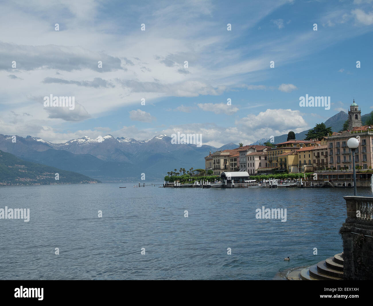 Città di Bellagio sul Lago di Como in Italia con scalini fino al lago e uno sfondo di montagna innevato nei primi mesi d'estate Foto Stock