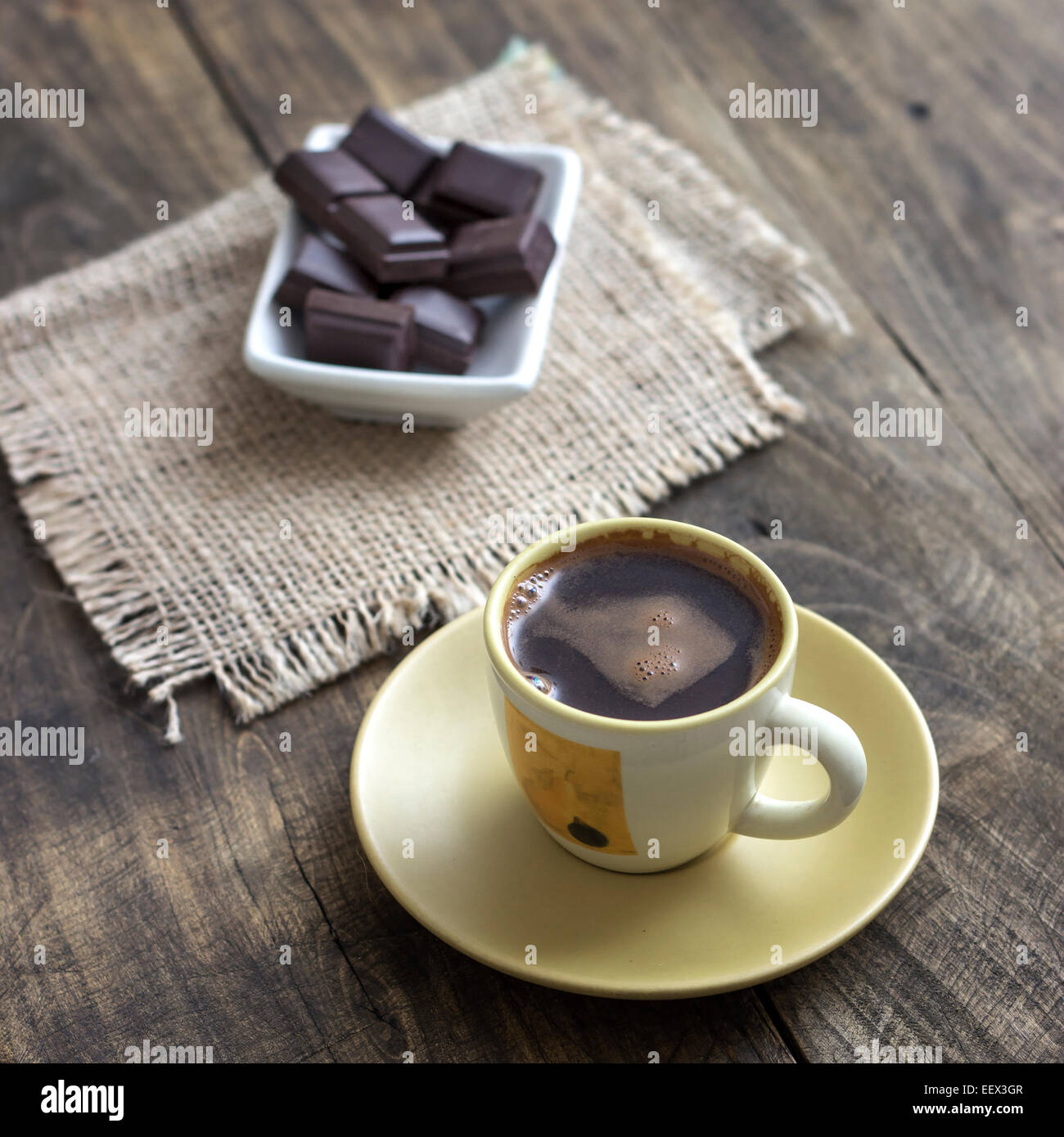 Tazza di caffè con cioccolato e tovagliolo sulla tavola di legno Foto Stock